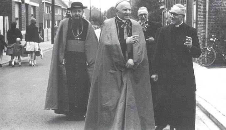 Mgr. Jansen, Mgr. Daem, E.H. A. Desmedt en zijn broer Raphaël wandelen door het kerkblok